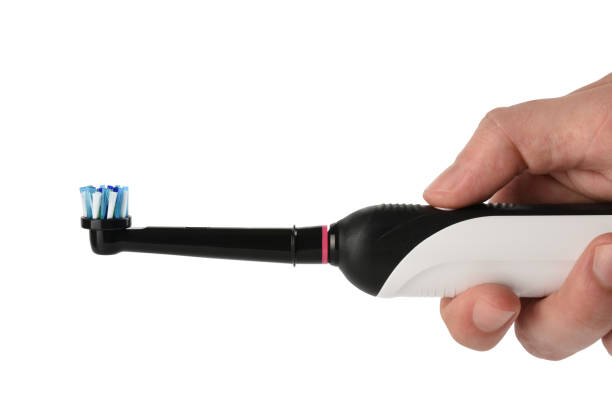 istock Hand holding electric toothbrush on white background with clipping path 1337211976