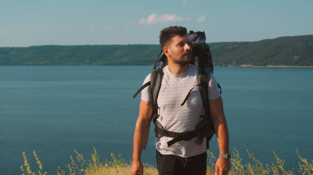istock The handsome man walking with backpack along the coast 1337212115