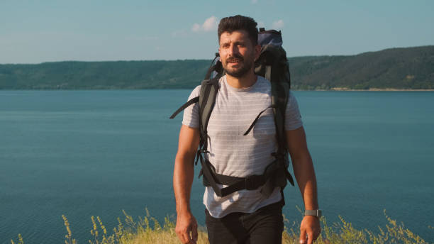 istock The handsome man walking with backpack along the coast 1337212118