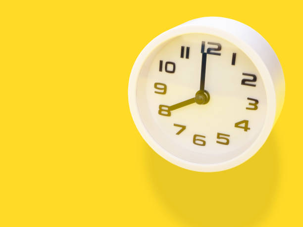 istock Close up, white clock showtime at 8 o'clock on office yellow workplace tabletop. Copy space for your text. Business and education concept. 1337212540