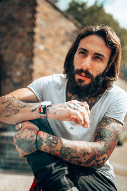 uomo hipster con tatuaggio che fuma - stubble men tattoo sensuality foto e immagini stock