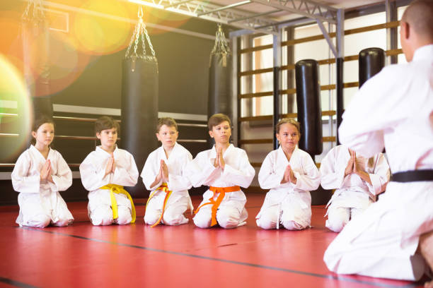 istock Group of karate kids and trainer in gym 1337214566