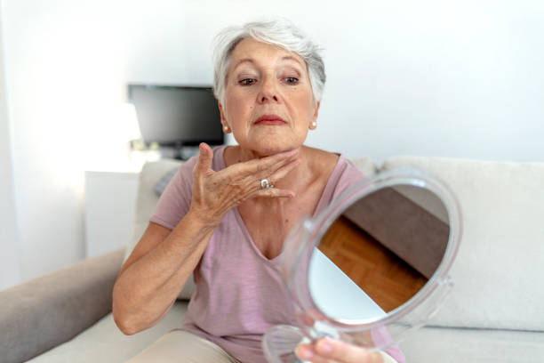 istock Woman applying face cream while looking herself in the mirror. 1337215046