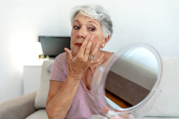istock Reflection of aged lady while putting on cream. 1337215089