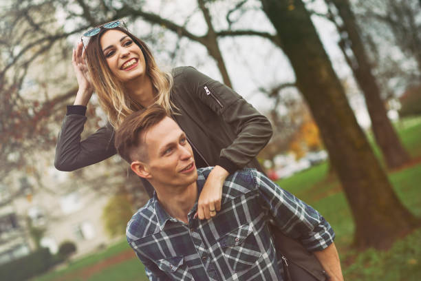 istock Piggyback young couple in park 1337217797