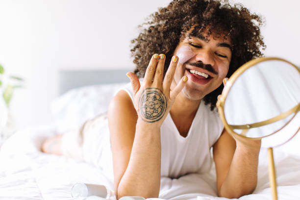 istock Gender nonconforming man applying makeup to his face 1337218158