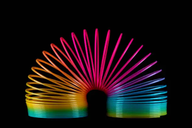 Colourful slinky spring toy isolated on a black background