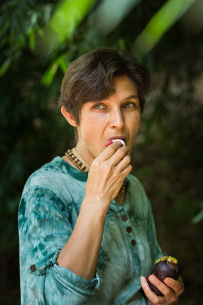 istock woman eats mangosteen in nature, vegetarian concept 1337221371