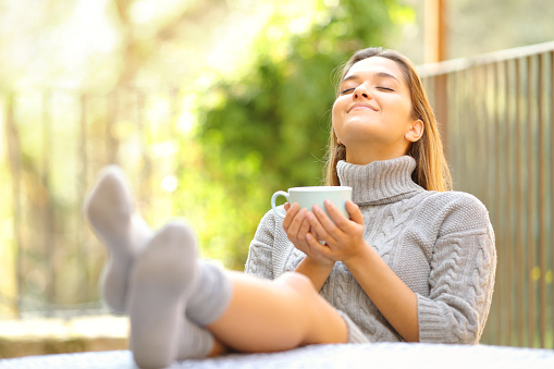 Woman breathing relaxing drinking coffee in a garden