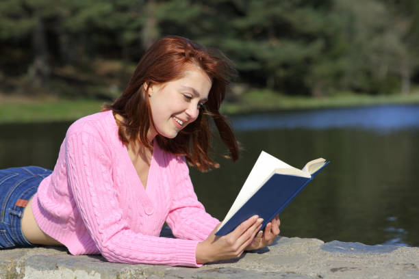 istock Woman reading a book lying in the mountain 1337224006