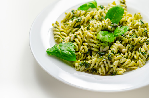 Pesto and pine nut pasta salad, fusilli pasta with regato cheese and baby spinach coated in basil pesto, Italian food