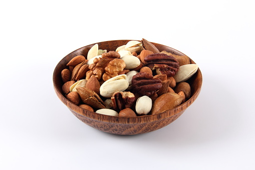 Wooden bowl with mixed nuts on white background