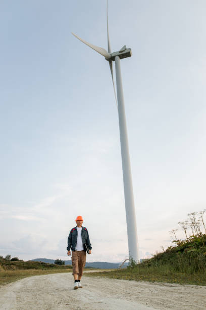 istock Man walking in front of wind turbines 1337226070