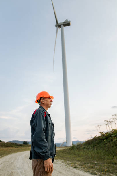 ingeniero senior de pie frente a la turbina eólica - wind turbine motion alternative energy wind power fotografías e imágenes de stock