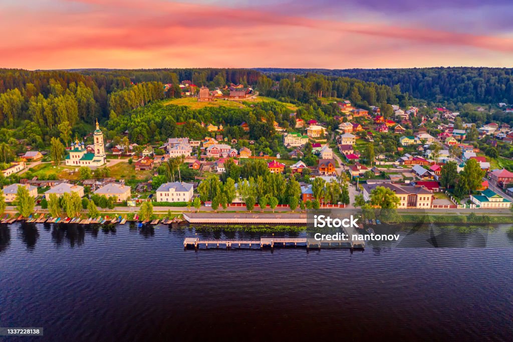 Aerial drone view of ancient russian town Ples on the Volga river with colorful sunset Aerial drone view of ancient russian town Ples on the Volga river with colorful sunset. Ivanovo - Russia Stock Photo