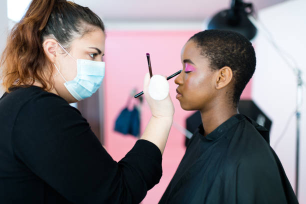 istock Side view make up artist applying make up to model back stage 1337228472