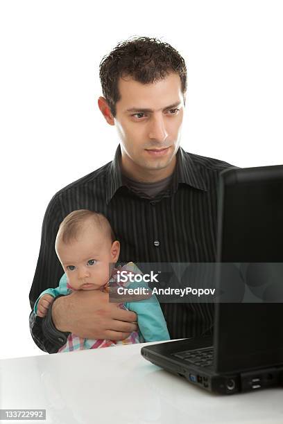 Padre Lavorando Su Un Portatile Mentre Il Servizio Di Babysitter - Fotografie stock e altre immagini di Accudire