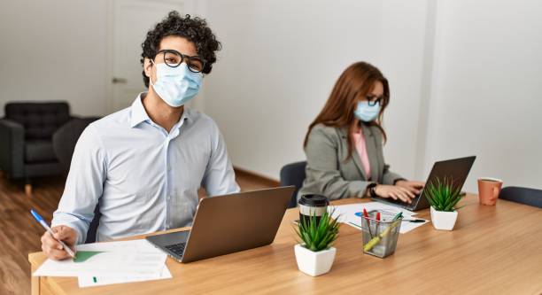 istock Two business workers wearing medical mask working at the office. 1337230029