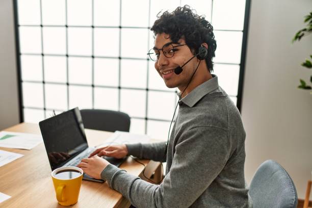 istock Young hispanic call center agent man smiling happy working at the office. 1337230121