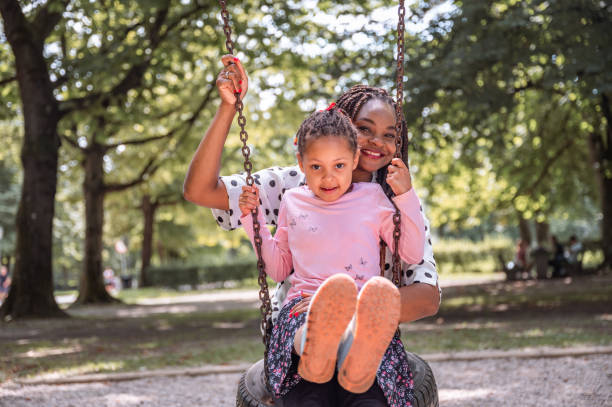 istock Mother and daughter having fun on a swing 1337235918