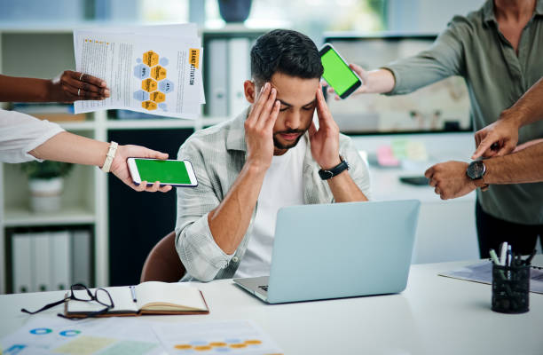 istock Shot of a young man experiencing a headache at work while being overwhelmed 1337236067