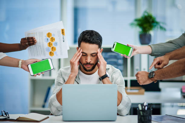 istock Shot of a young man experiencing a headache at work while being overwhelmed 1337236069