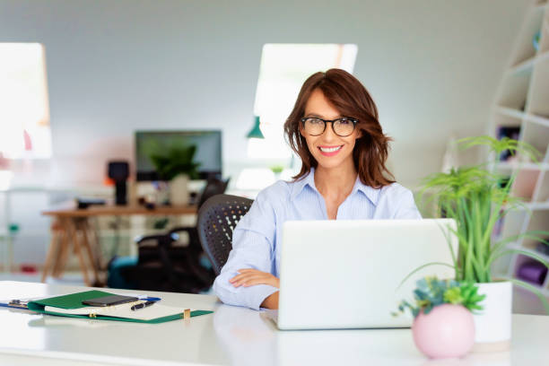 istock Confident businesswoman using laptop while working at office desk 1337237070