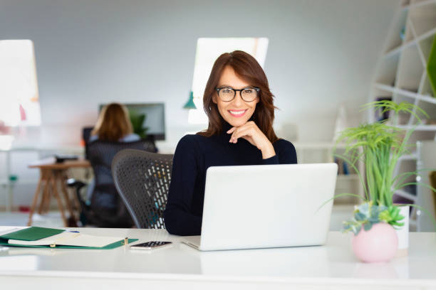 istock Attractive businesswoman using laptop while working at the office 1337237075