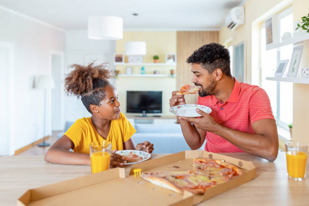 istock Dad and daughter eat pizza 1337237582