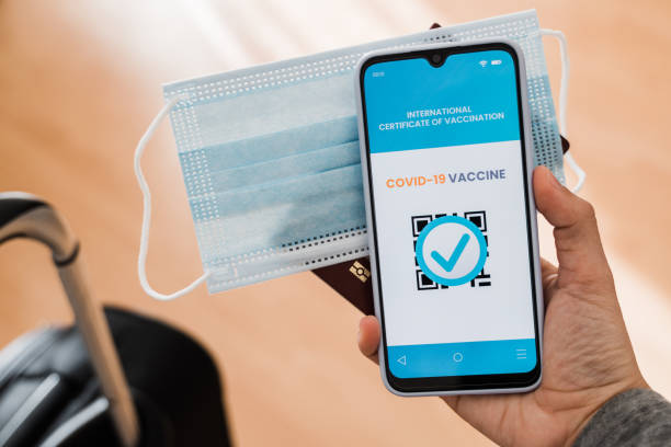 istock Traveler holding digital covid passport certification on smartphone inside international airport - Coronavirus vaccine, travel trend technology concept - Focus on hand 1337240117