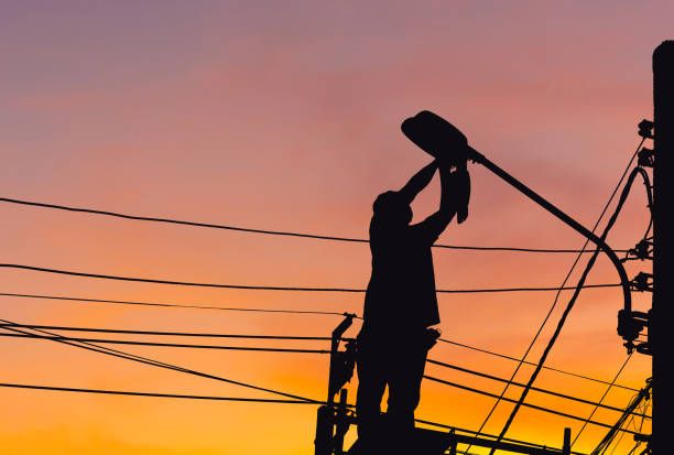 silhouette of electrician checking lighting to the led street lamp post, technician with clipping path and maintenance service concepts - city of tool imagens e fotografias de stock