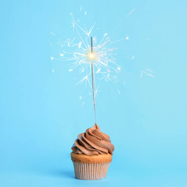 istock Birthday cupcake with sparkler on light blue background 1337243878