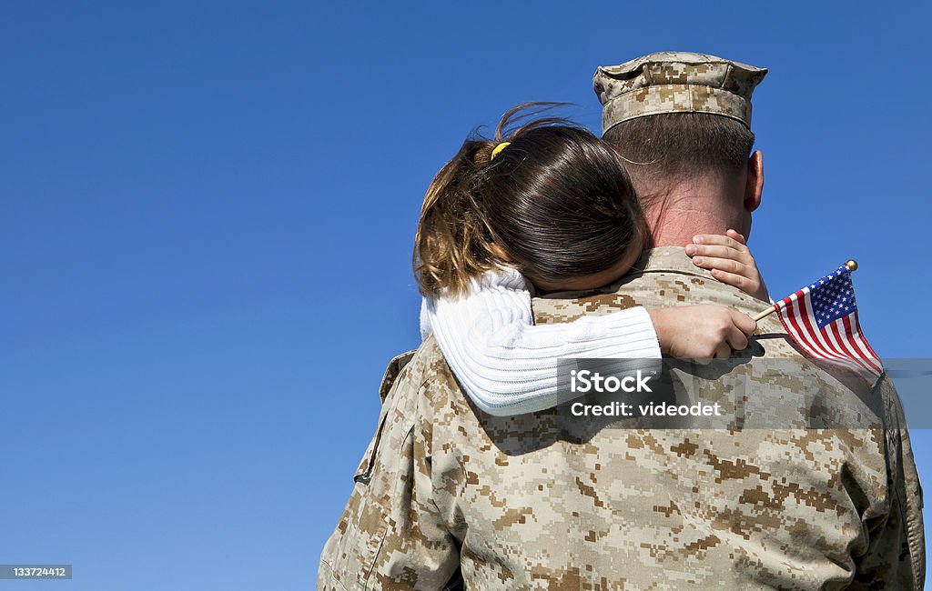 Military Man Hugs Daughter Military man hugs his child Veteran Stock Photo