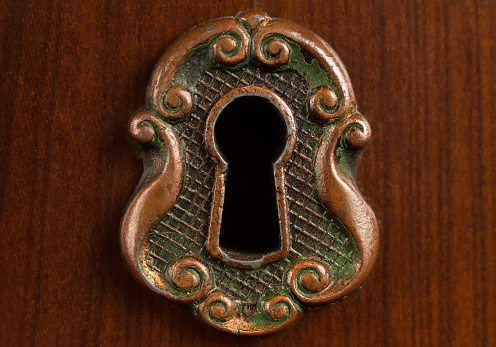 Decorative design of the keyhole. The face of the castle in the old style against the background of a tree.