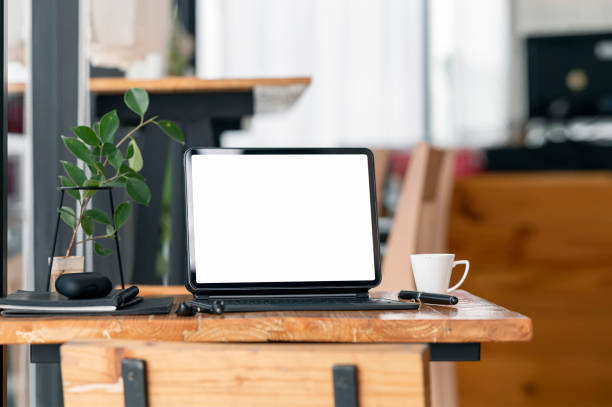 istock Blank screen tablet and gadget on wooden table in cafe room. 1337246570