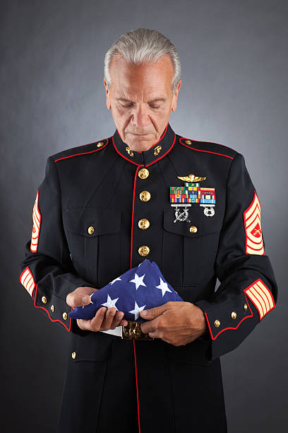 traurig marine holding eine flagge - us marine corps stock-fotos und bilder