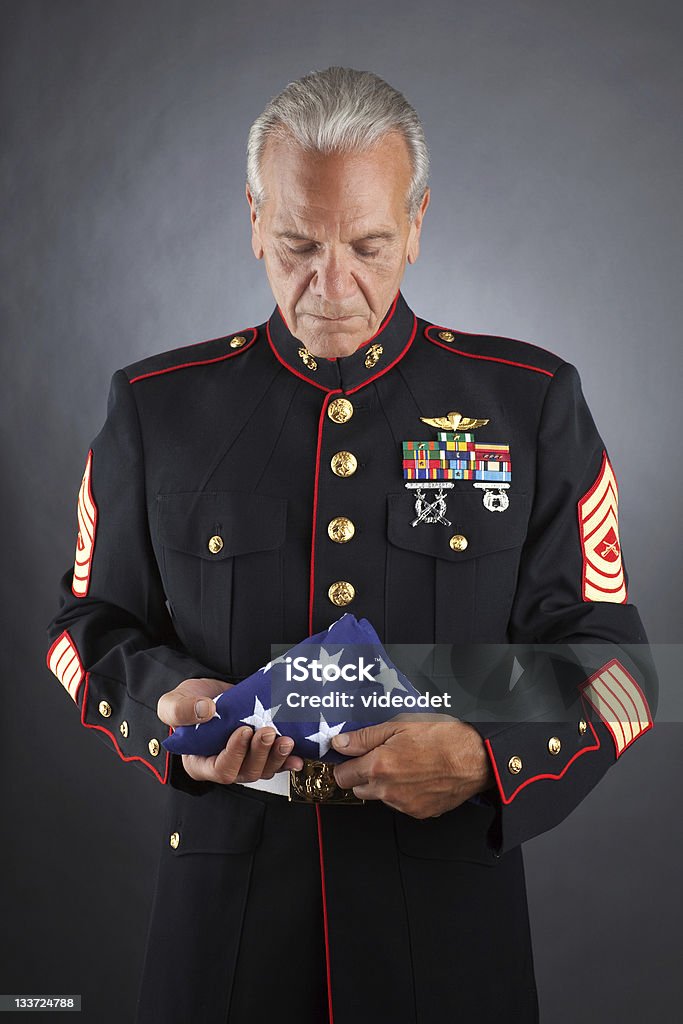 Sad Marine Holding a flag A military member holds a folded flag Veteran Stock Photo