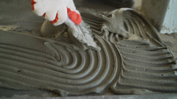 istock The process of applying mortar for laying ceramic tiles. Leveling ceramic tile mortar on the floor. Installation of adhesive solution for gluing ceramic tiles to the floor 1337250563