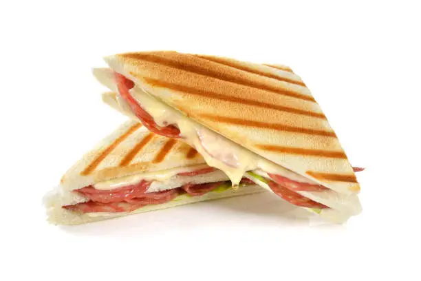 Grilled double sandwich with Italian salami and melting cheese on white background