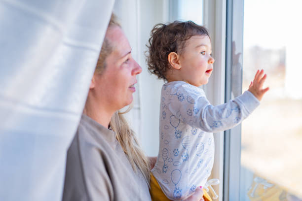 istock Mother holding her baby boy by the window 1337253178
