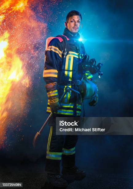 Firefighter In Front Of Fire And Blue Light Stock Photo - Download Image Now - Firefighter, Fire Station, Germany