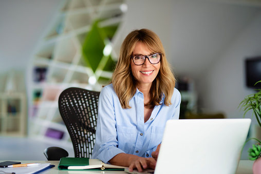 Portrait shot of executive financial advisor businesswoman working on laptop at the office.