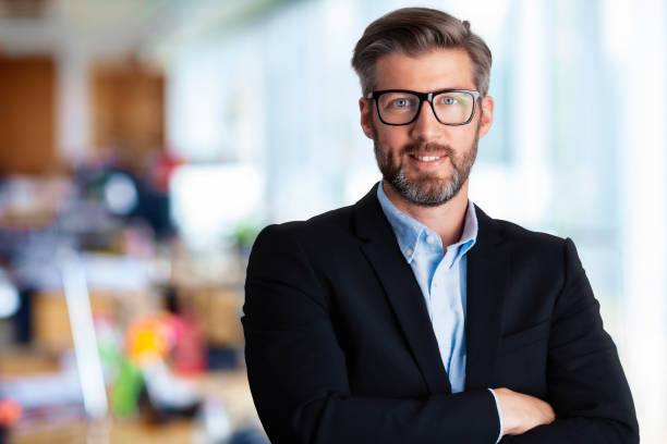 istock Handsome businessman wearing eyeglasses and suit while standing at the office 1337254669