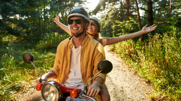 istock Happy young caucasian couple driving scooter 1337256666