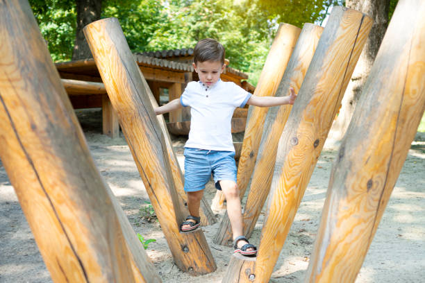 istock Children's obstacle course on a modern playground. Kid crossing a wooden bridge. Development of the child's agility and courage. 1337256672