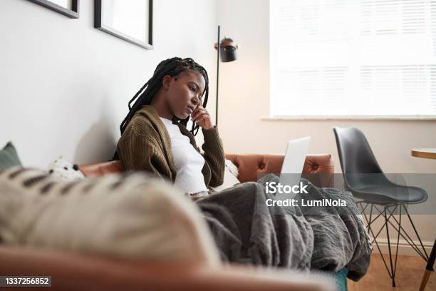 Shot Of A Young Woman Looking Confused While Using A Laptop At Home Stock Photo - Download Image Now