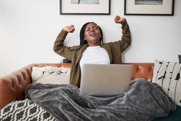 istock Shot of a young woman stretching while using a laptop at home 1337256857