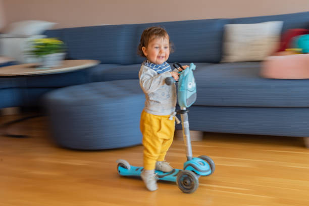 istock Boy riding scooter at home 1337257095