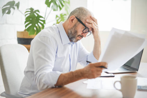istock mature adult man working from office ( with laptop, paperwork, Negative Emotion) 1337258851