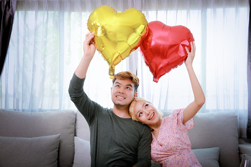 Selective focus heart shape of air balloons, Young couple with heart shape of air balloons, Celebration of Saint Valentine's Day
